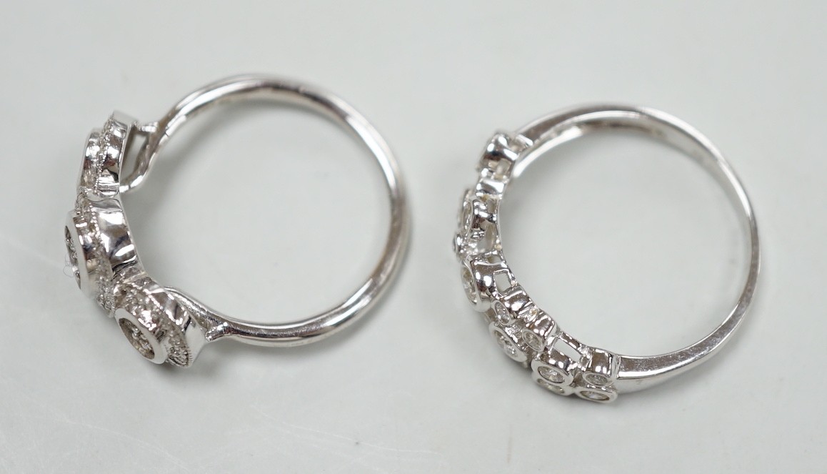 A modern 18ct white gold and diamond set triple cluster ring, size M and a similar 18ct white gold and collet set diamond cluster ring, size N, gross weight 7.5 grams.